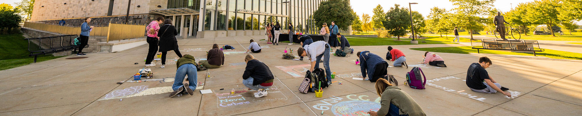 Students draw with chalk to bring their research to life through the use of art.